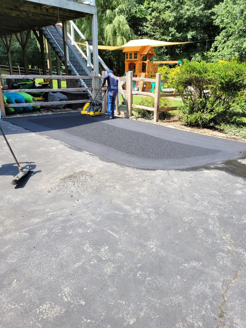 A hot-mix patch cut into an older driveway